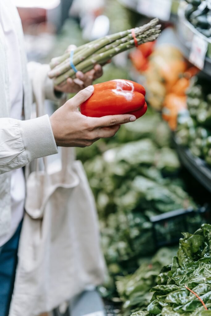 Klant kiest verse groenten tijdens het boodschappen doen in een supermarkt